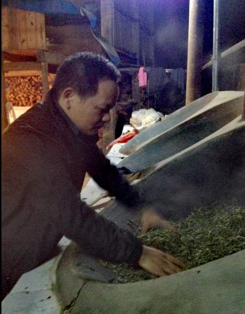 My father hand-roasting tea leaves during primary processing.